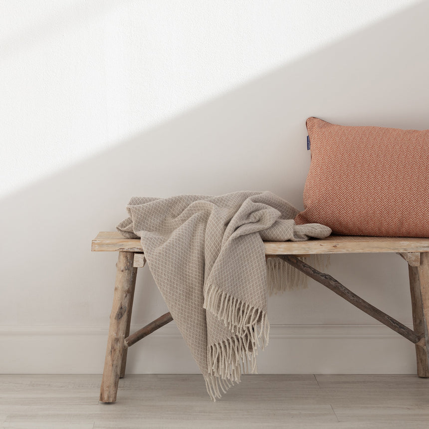 Beige throw in a small diamond weave with a fringe