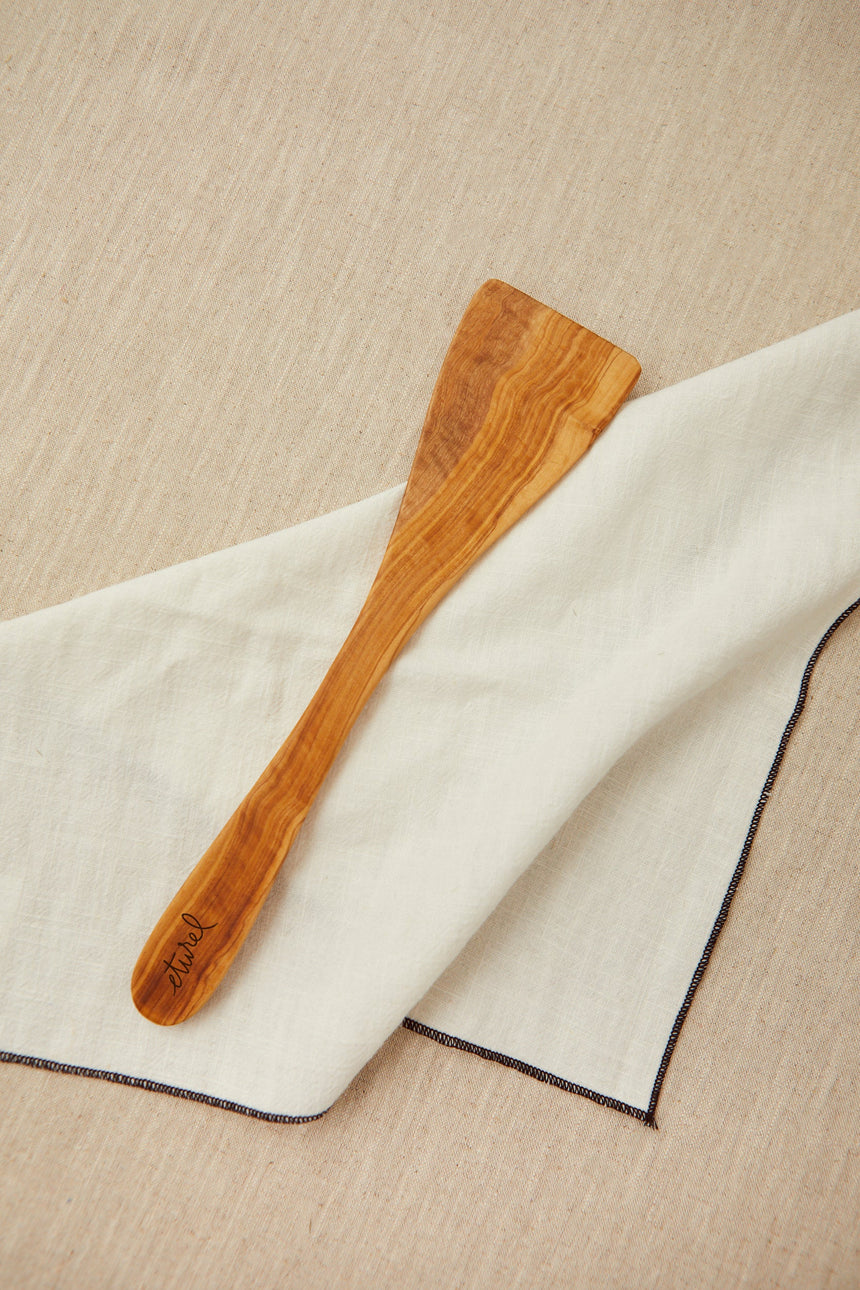 Curved kitchen spatula cut from a single piece of olive wood