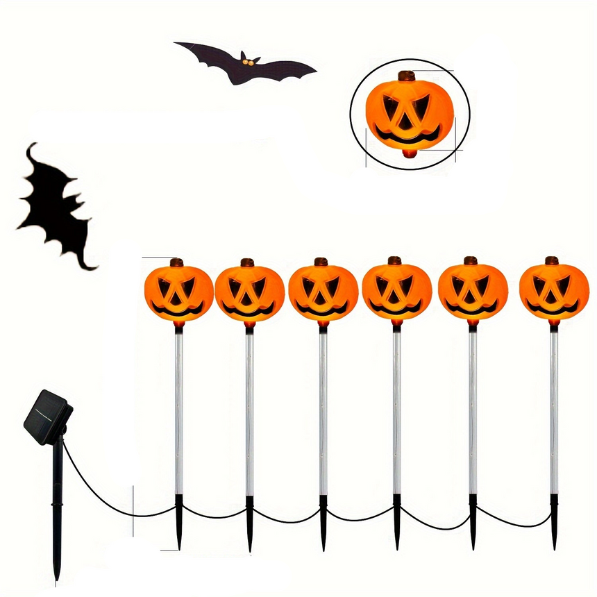 Six pumpkin face garden lights on stakes with a solar panel