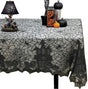 Black lace Halloween tablecloth with a haunted house design on a table