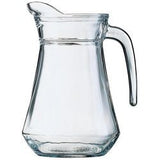 Clear glass water jug with a curved handle and faceted base