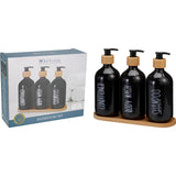 Three matching bathroom dispenser bottles standing together on a tray
