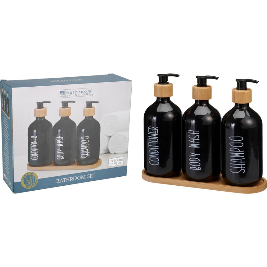 Three matching bathroom dispenser bottles standing together on a tray
