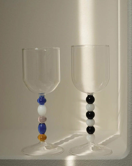 Two wine glasses with clear bowls and stems of coloured glass beads