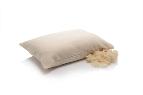 Merino wool pillowcase on a pillow beside a tuft of raw wool