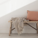 Beige throw in a small diamond weave with a fringe