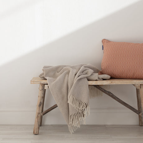 Beige throw in a small diamond weave with a fringe