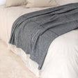 Dark grey throw with a faint light check and a cream fringe