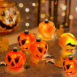 Glowing pumpkin lights among autumn leaves
