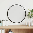A small round wall mirror in a slim black frame