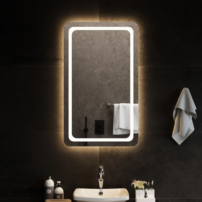 A tall rectangular bathroom mirror, a metre high, lit by an integrated LED strip