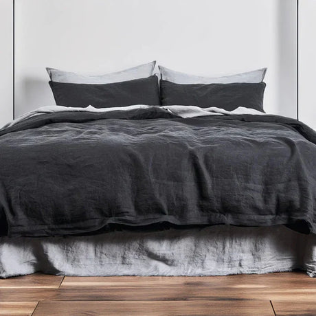 A charcoal linen-cotton duvet cover on a bed, with a wooden floor beneath