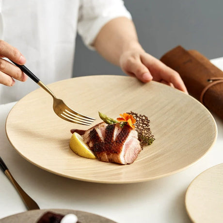 Flat porcelain dinner plate with a wide rim, beige or brown
