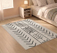 Off-white vinyl rug with black chevron and leaf motifs in a bedroom