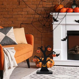 Black iron Halloween tree with hanging pumpkins beside a fireplace