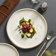 Ivory ceramic dinner plate with a raised toasted rim and a plated salad