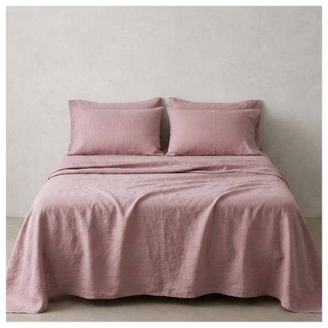 A dusty pink linen-cotton sheet set made up on a bed, shown from the front