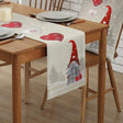 Natural linen table runner printed with Christmas gnomes and red hearts on a dining table