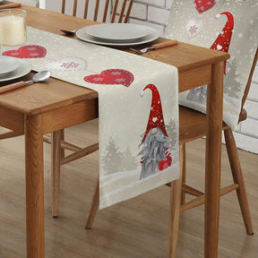 Natural linen table runner printed with Christmas gnomes and red hearts on a dining table