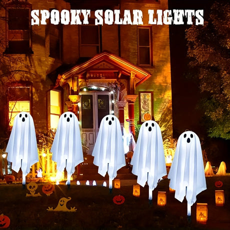 Five white ghost solar lights on stakes in a garden at night