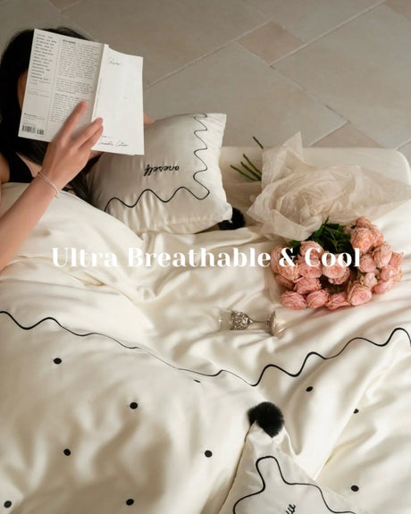 Ivory lyocell duvet cover set with black polka dots, wavy line embroidery and pompoms
