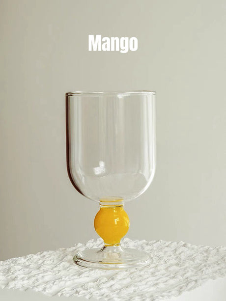 A clear wine glass with a yellow gumball stem