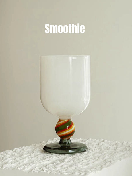 An opaque white wine glass with a striped gumball stem in green, red and yellow