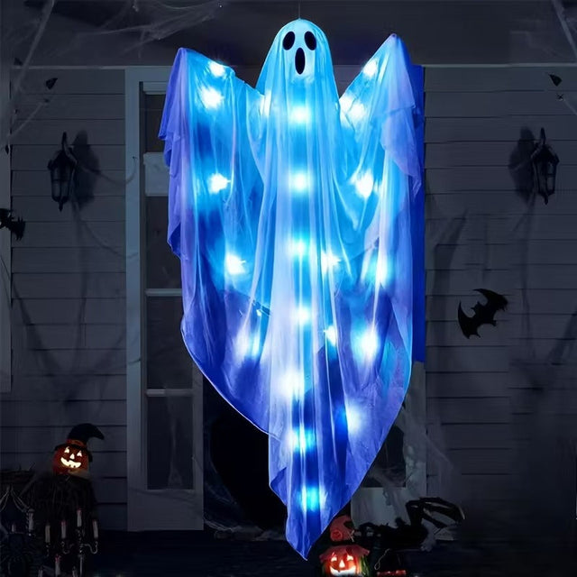Hanging fabric ghost lit by LEDs outside a house at night