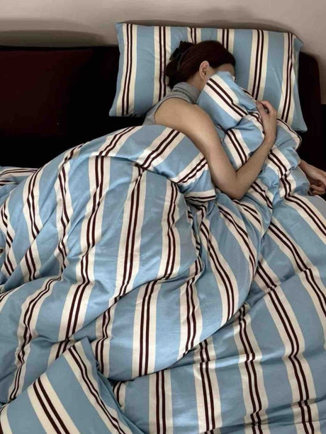 Bed made up in light blue, cream and burgundy striped cotton jersey bedding