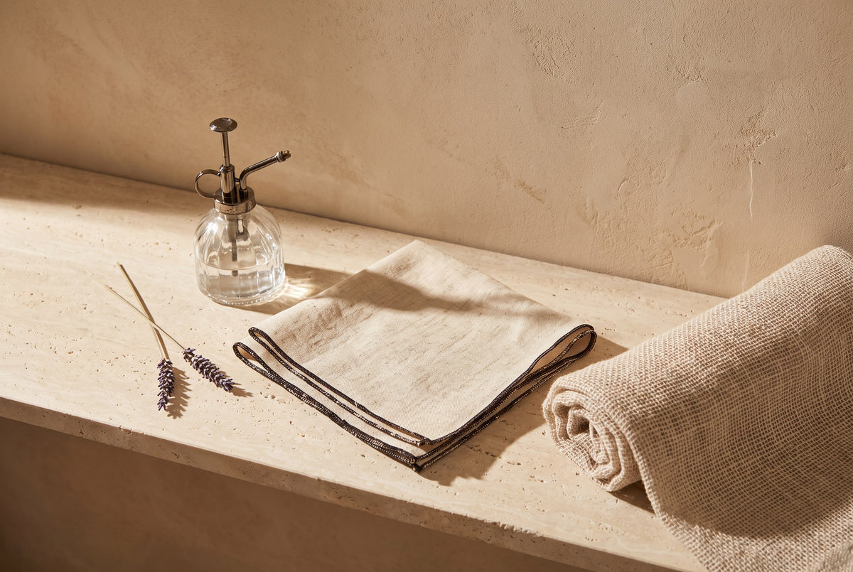 Pressed linen napkin, rolled towel and a water mister for damp-ironing linen