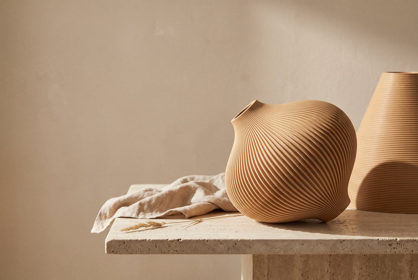 Two natural wood-tan 3D-printed ridged pendant lampshades with a soft dusting cloth
